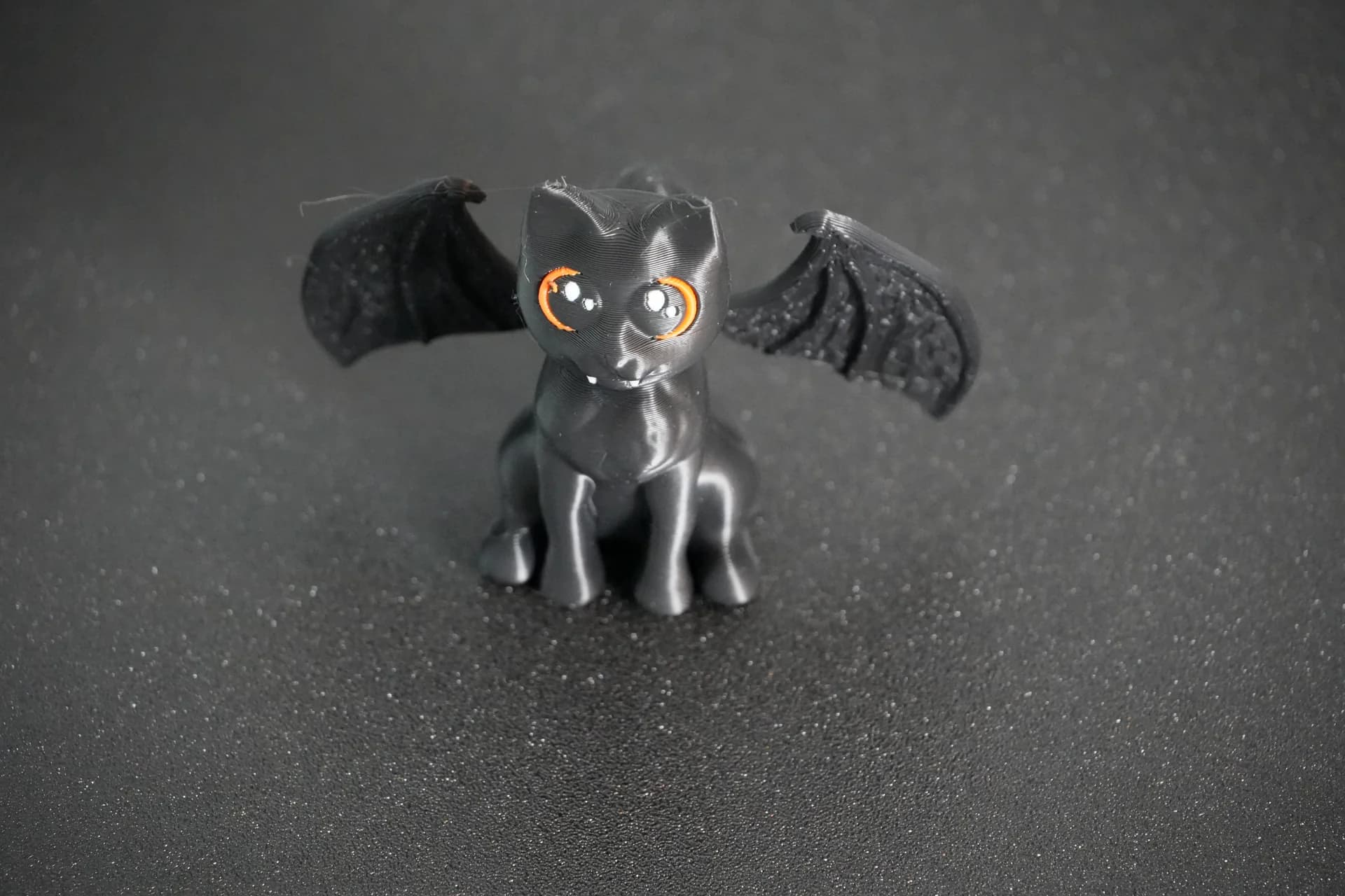 Black flying cat with orange and white eye details printed on an Anycubic Kobra X