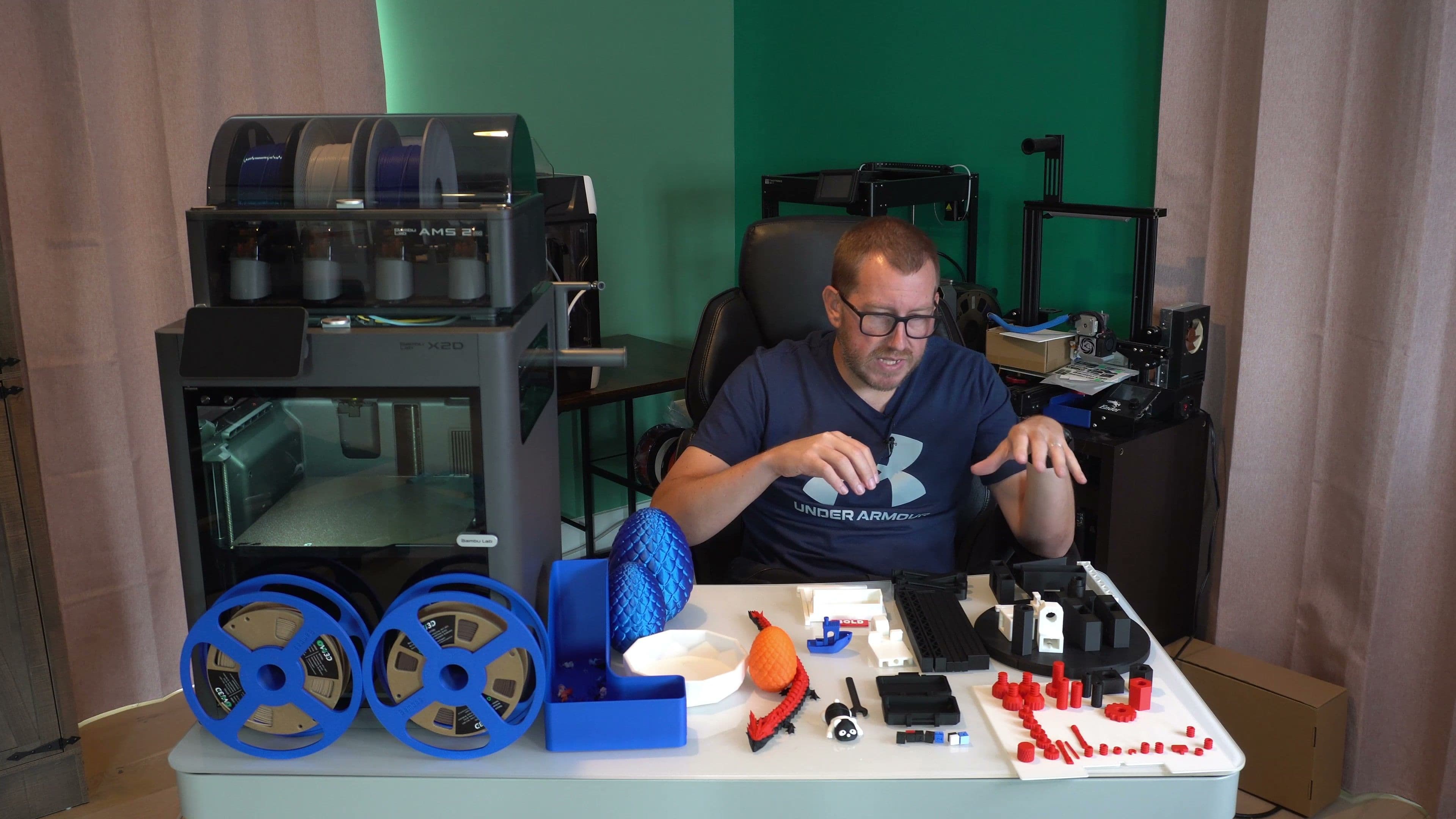 Rob from 3DPrintscape evaluating prints beside a Bambu Lab X2D printer