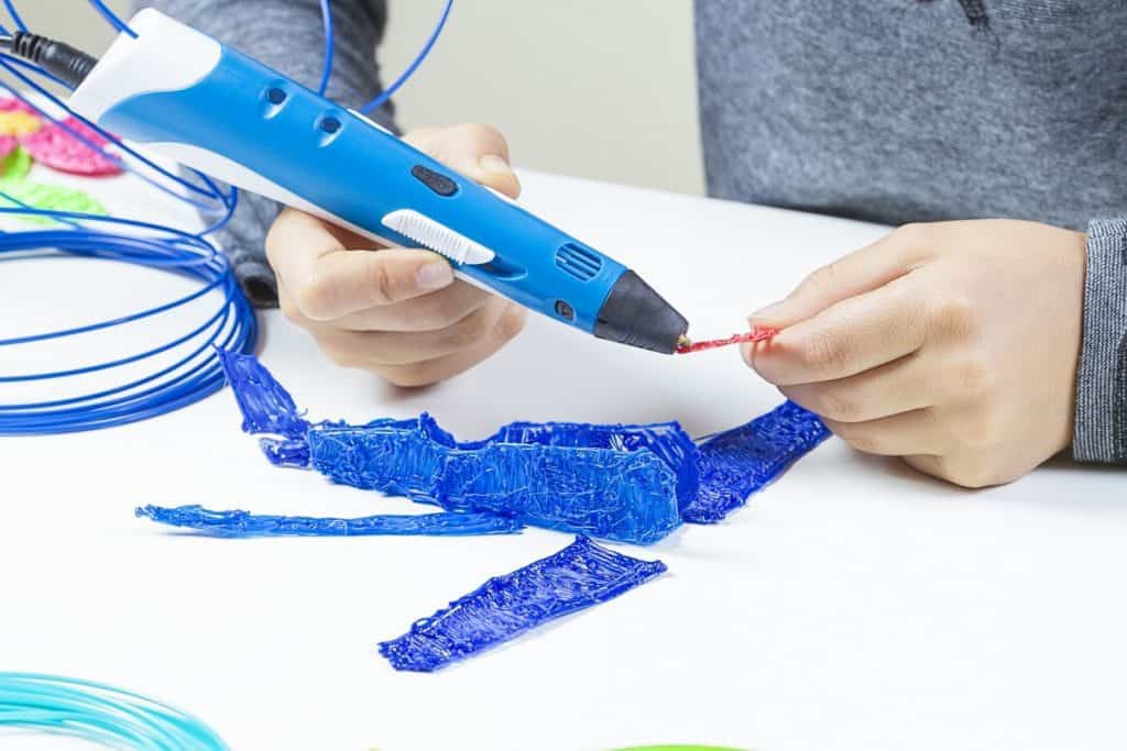 Kid`s hands creating with 3d pen