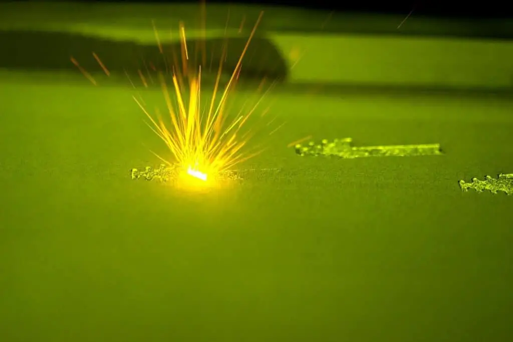 3D printer printing three-dimensional object from metal powder.